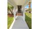 Inviting front entrance with a tiled porch, pillars, and a well-kept lawn at 8896 Reymont St, Orlando, FL 32827