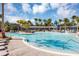 Wonderful community pool featuring a splashpad, lounge seating, fountains, palm trees, a modern clubhouse and a clear blue sky at 8896 Reymont St, Orlando, FL 32827
