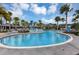 Lovely community pool featuring a splashpad, lounge seating, fountains, palm trees, a modern clubhouse, and a clear blue sky at 8896 Reymont St, Orlando, FL 32827