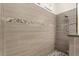 Modern shower with pebble accents, tiled walls, and sleek fixtures at 8896 Reymont St, Orlando, FL 32827