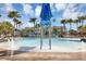 Inviting community splashpad featuring an overhead water feature, lounge seating, fountains, palm trees, and a modern clubhouse at 8896 Reymont St, Orlando, FL 32827