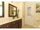 Bathroom features a single vanity with tan countertop, dark wood cabinets and a door to the exterior at 1157 Duncan Dr, Winter Springs, FL 32708
