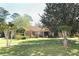 Inviting single-story home with mature trees, a well-manicured lawn, and a brick facade at 1157 Duncan Dr, Winter Springs, FL 32708