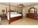Main bedroom featuring a four-poster bed, ceiling fan, and ensuite bathroom at 1157 Duncan Dr, Winter Springs, FL 32708