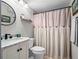 Well-lit bathroom featuring a vanity with marble countertop and a shower with a stylish curtain at 128 Waverly Pl # 128, Orlando, FL 32806
