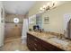 Bathroom featuring updated vanity with granite countertop and tiled walk-in shower with rainfall showerhead at 128 Waverly Pl # 128, Orlando, FL 32806