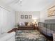 Bright bedroom features a sofa, closet, crib, and overhead lighting at 128 Waverly Pl # 128, Orlando, FL 32806