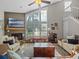 Bright living room featuring a vaulted ceiling, fireplace, and large windows with natural light at 128 Waverly Pl # 128, Orlando, FL 32806