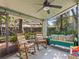 Inviting screened porch with rocking chairs and a cozy swing, perfect for outdoor relaxation at 128 Waverly Pl # 128, Orlando, FL 32806