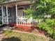 Inviting front porch featuring a porch swing, flower bed, and white railings at 13018 S Sunset Ter, Winter Garden, FL 34787