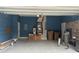Spacious garage with blue walls, storage shelving, water heater and garage door at 13018 S Sunset Ter, Winter Garden, FL 34787