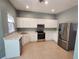 Bright kitchen featuring stainless steel appliances and white cabinets at 13018 S Sunset Ter, Winter Garden, FL 34787