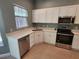 Well-lit kitchen with stainless steel appliances, white cabinets, and a window at 13018 S Sunset Ter, Winter Garden, FL 34787