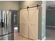 Kitchen with stainless steel refrigerator and white sliding barn doors at 13018 S Sunset Ter, Winter Garden, FL 34787