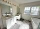 Bright bathroom with dual sinks, tub, shower, decorative tile floor, and ample natural light at 138 W Stetson Ave, Deland, FL 32720