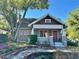 Charming bungalow-style home with a red front door, covered porch, and mature landscaping at 138 W Stetson Ave, Deland, FL 32720
