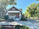 Charming bungalow-style home with a red front door, and a long driveway at 138 W Stetson Ave, Deland, FL 32720