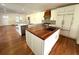 Modern kitchen with a wood-topped island, stainless steel appliances, and white cabinetry at 138 W Stetson Ave, Deland, FL 32720