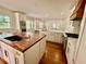 Well-lit kitchen with a wood island, white cabinets, stainless appliances, and recessed lighting at 138 W Stetson Ave, Deland, FL 32720