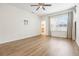 Spacious bedroom with wood-look flooring, ceiling fan, and a large window with window treatments at 1457 Resolute St, Celebration, FL 34747