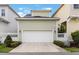 Spacious two-car garage with a clean, modern door, complemented by tidy landscaping and a white picket fence at 1457 Resolute St, Celebration, FL 34747