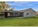 Exterior view of the home with a screened-in patio and a spacious backyard at 1563 W Finland Dr, Deltona, FL 32725