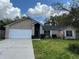 Single story brick home with a well-maintained lawn and a two car garage at 1563 W Finland Dr, Deltona, FL 32725