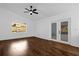 Bright, airy living room featuring wood-look flooring, a ceiling fan, and access to the outdoors through French doors at 1563 W Finland Dr, Deltona, FL 32725