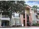 Charming condo building featuring a private balcony, stairs to upper floors, and lush tropical landscaping at 1969 Summer Club Dr # 209, Oviedo, FL 32765