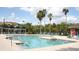 Beautiful community pool area featuring clear blue water, brick pavers, and palm tree landscaping at 1969 Summer Club Dr # 209, Oviedo, FL 32765