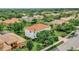 Expansive aerial view of a white two-story house with a red tile roof nestled among lush greenery at 2107 Rickover Pl, Winter Garden, FL 34787