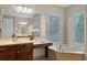 Bright bathroom featuring a large soaking tub and vanity with a garden view at 2107 Rickover Pl, Winter Garden, FL 34787