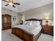 Spacious bedroom with a tray ceiling, warm lighting, and stylish wooden furniture at 2107 Rickover Pl, Winter Garden, FL 34787