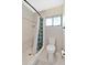 Bathroom shower with neutral tile, shower curtain and frosted window for natural light at 218 Nettlewood Ln, Fern Park, FL 32730