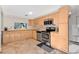 Well-lit kitchen boasts stainless steel appliances, light wood cabinetry, and stylish tile flooring for modern living at 218 Nettlewood Ln, Fern Park, FL 32730