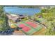 Aerial shot of tennis courts next to clubhouse and a nearby lake at 218 Nettlewood Ln, Fern Park, FL 32730