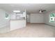 Open-concept living room with neutral carpet, natural light and adjacent kitchen at 22 Laurel Crse, Ocala, FL 34480