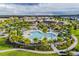 Beautiful aerial view of the community pool with palm trees and manicured lawn with blue skies and fluffy white clouds at 2352 Zaballina Pl, Kissimmee, FL 34747