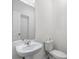 Simple bathroom with a pedestal sink, toilet, and mirror, offering a minimalist and clean design at 2352 Zaballina Pl, Kissimmee, FL 34747