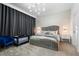 Well-decorated bedroom features a large gray headboard bed, modern light fixture and dark curtains at 2352 Zaballina Pl, Kissimmee, FL 34747