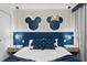 Themed bedroom featuring Mickey and Minnie Mouse wall decor, pendant lights, and a cozy bed setup at 2352 Zaballina Pl, Kissimmee, FL 34747