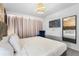 This bedroom features soft natural light, decor lighting, a wall-mounted TV, and tasteful modern decor at 2352 Zaballina Pl, Kissimmee, FL 34747