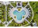 Aerial view of the community pool with lounge chairs, umbrellas, and tropical plants in a tranquil setting at 2352 Zaballina Pl, Kissimmee, FL 34747