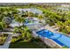 Aerial view of a community pool area with splashpad, slides, lounge chairs and umbrellas by the sparkling lake at 2352 Zaballina Pl, Kissimmee, FL 34747