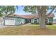 Inviting single-story home with a well-manicured lawn and mature trees providing shade at 2622 Jennifer Dr, Lakeland, FL 33810