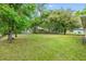 Green backyard offering ample space and mature trees at 304 Woods Landing Dr, Lady Lake, FL 32159