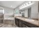 Luxurious bathroom with double sink vanity, soaking tub, and separate glass-enclosed shower at 304 Woods Landing Dr, Lady Lake, FL 32159