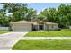 Charming single-story home with well-manicured lawn, mature trees, and a two-car garage at 304 Woods Landing Dr, Lady Lake, FL 32159