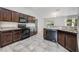 Modern kitchen with dark wood cabinets, granite countertops, and stainless steel appliances at 304 Woods Landing Dr, Lady Lake, FL 32159