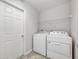 Laundry room with white washer and dryer, and overhead shelving at 304 Woods Landing Dr, Lady Lake, FL 32159